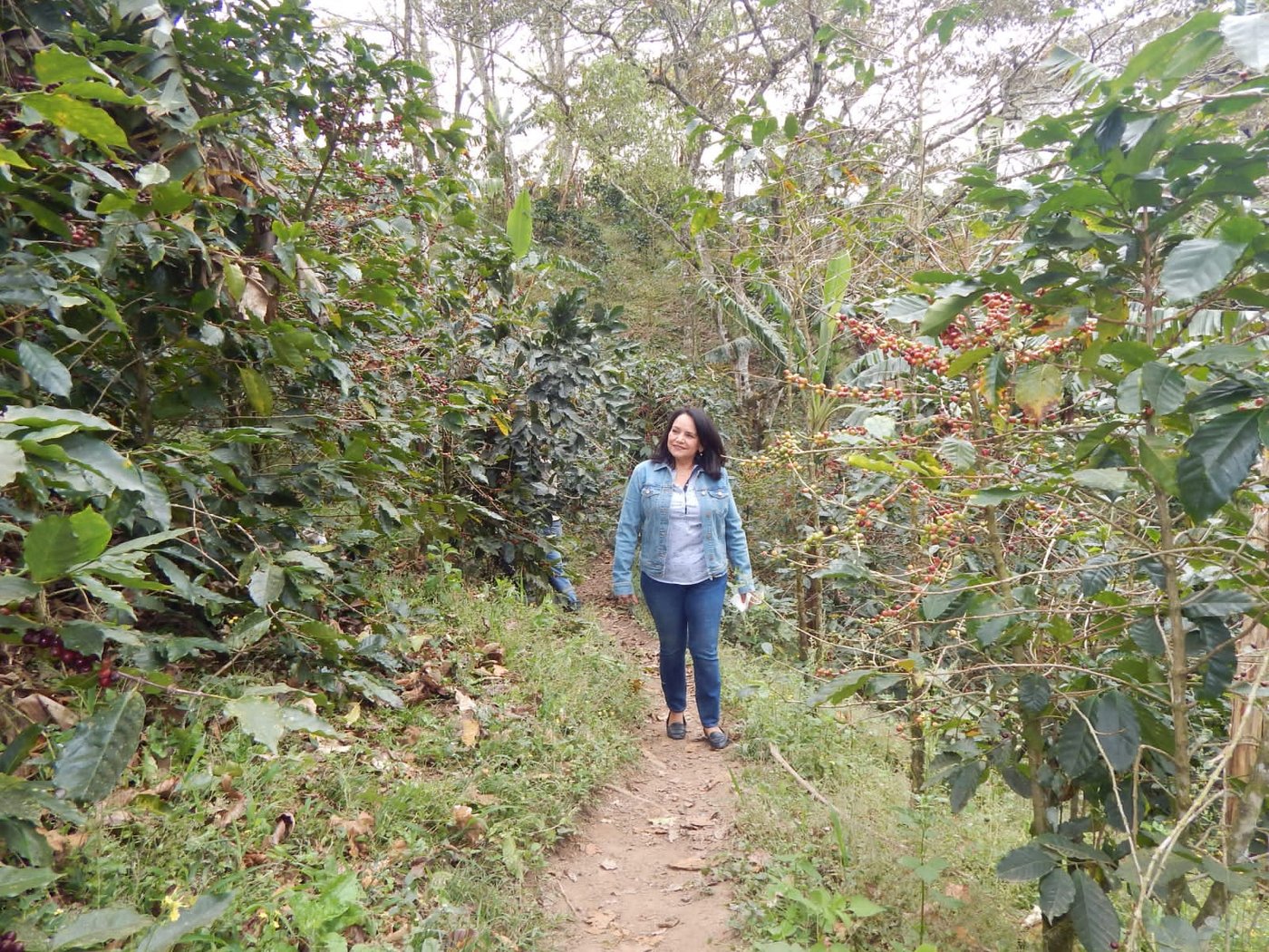 Maria Esther around her farm's coffee trees.