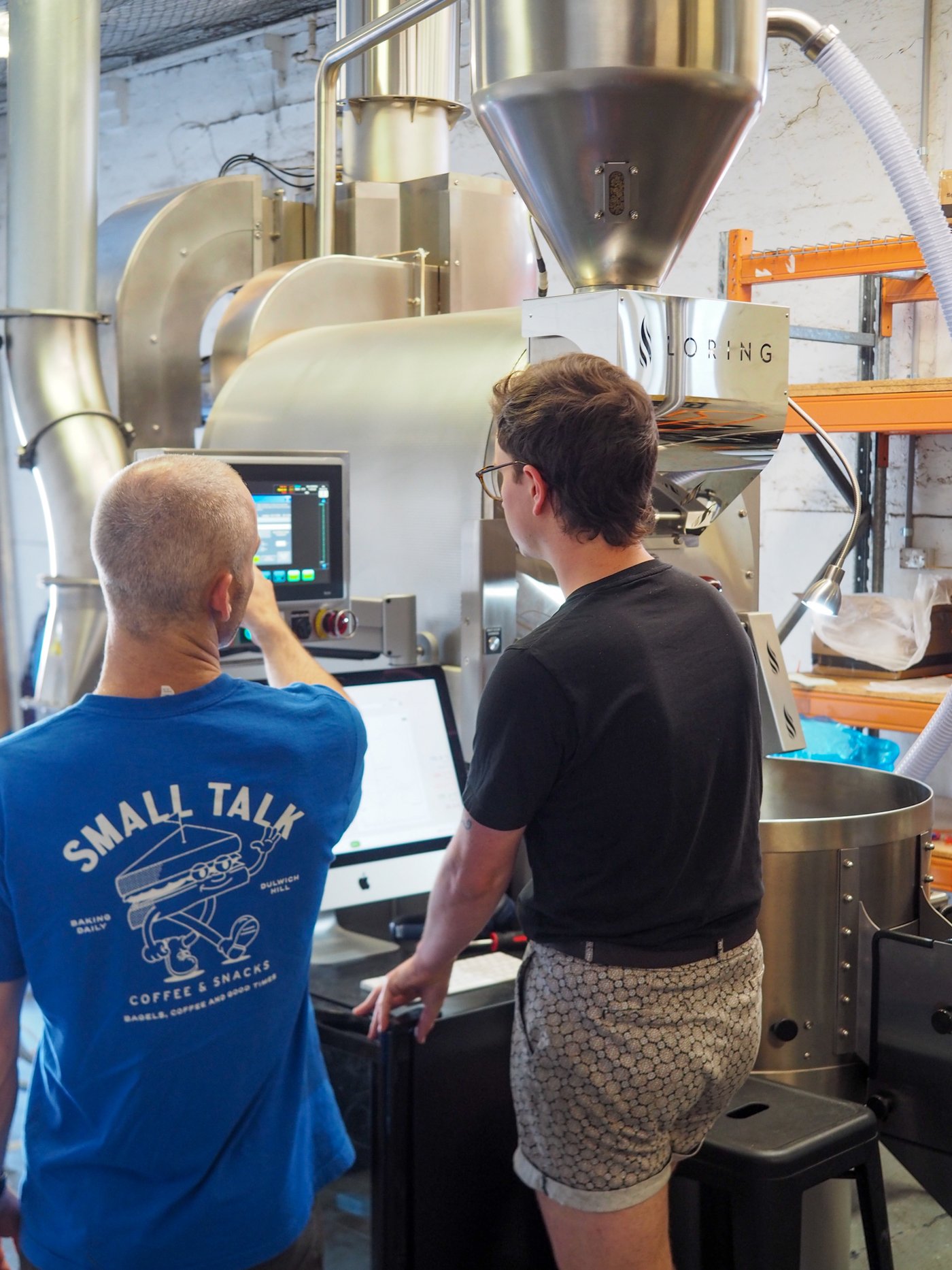 Reuben and a Sample Coffee staff member having a chat while roasting on our Loring Kestrel S35