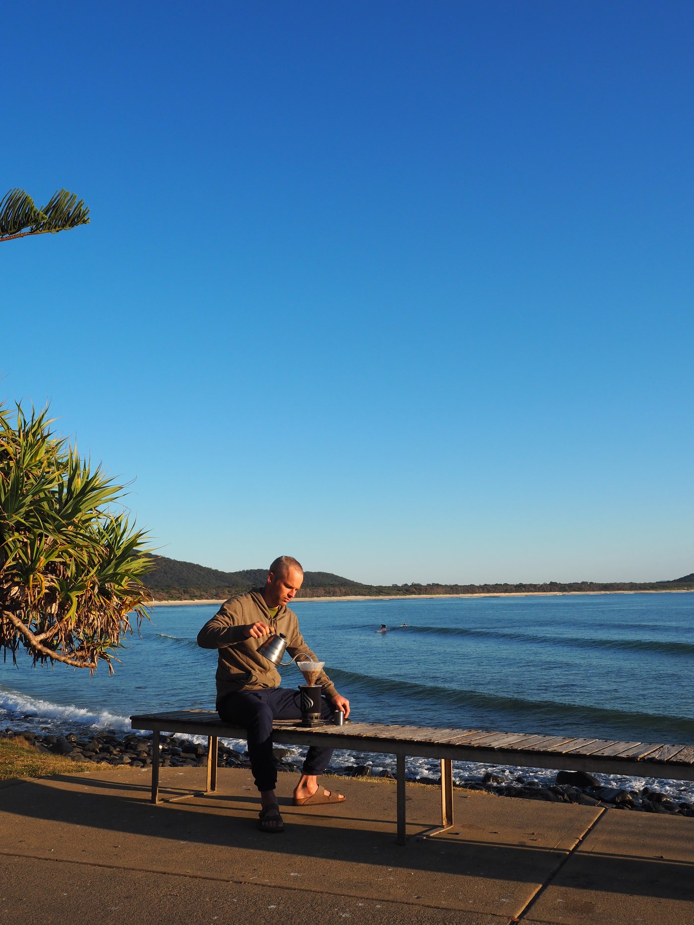 Reuben brewing coffee in a surf break in NSW. Beautiful blue sky, not much surf though.