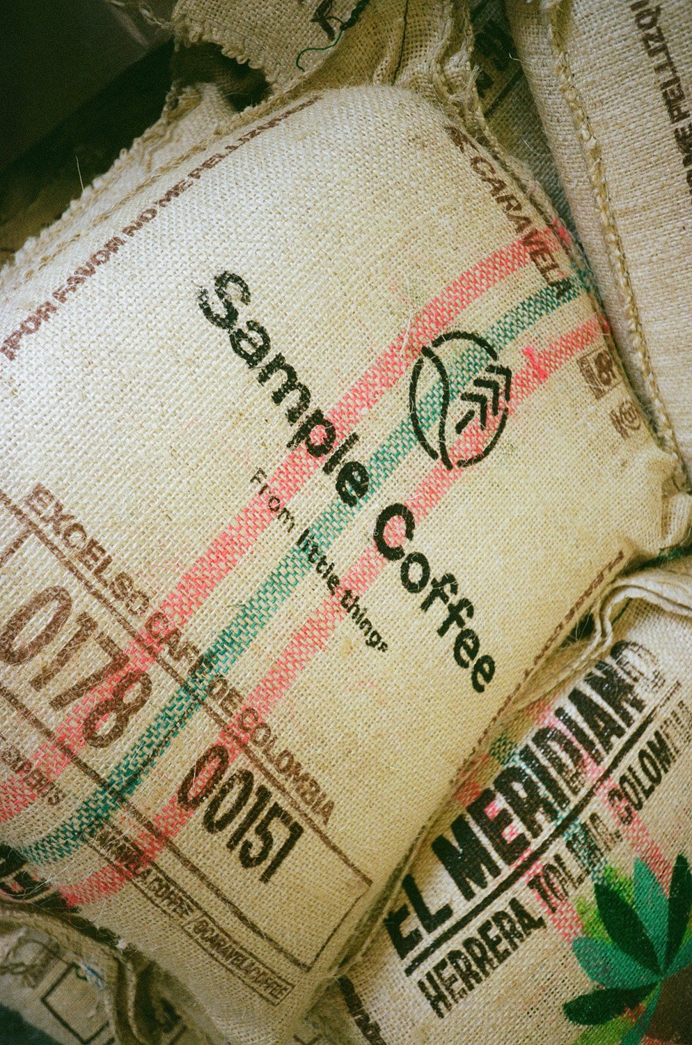 A hessian sack of Colombian green coffee branded as Sample Coffee.