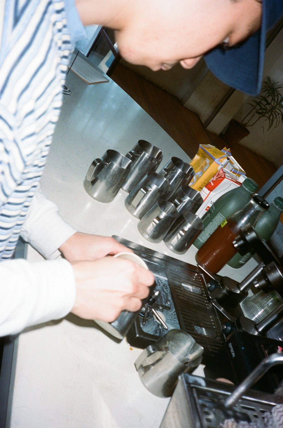 A barista making a latte coffee at Sample.