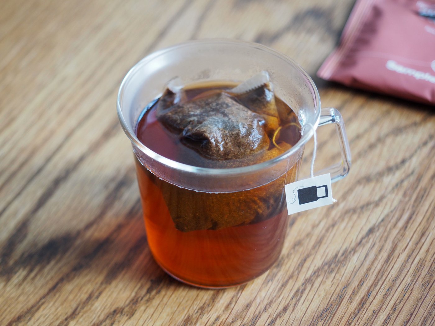 A steep bag steeping in a transparent cup.