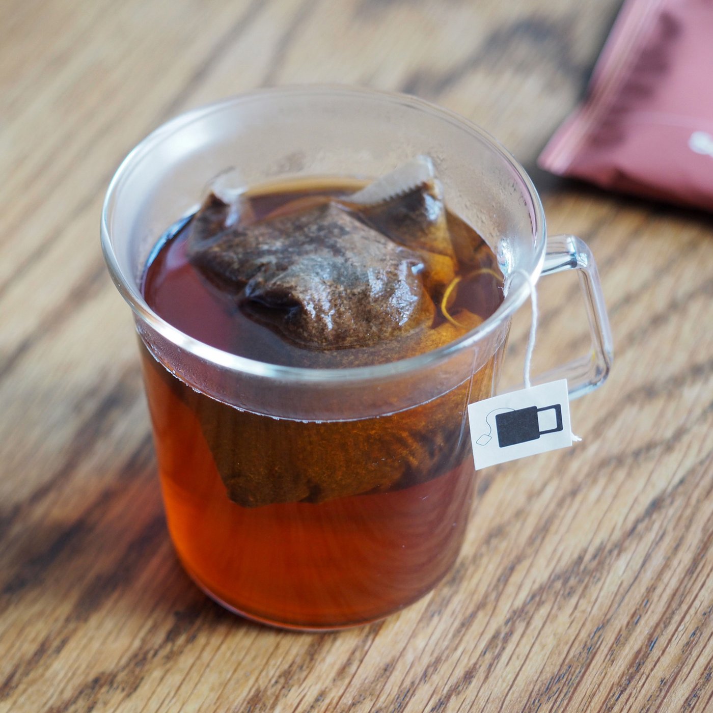 A Sample Coffee bag steeping in a transparent mug.