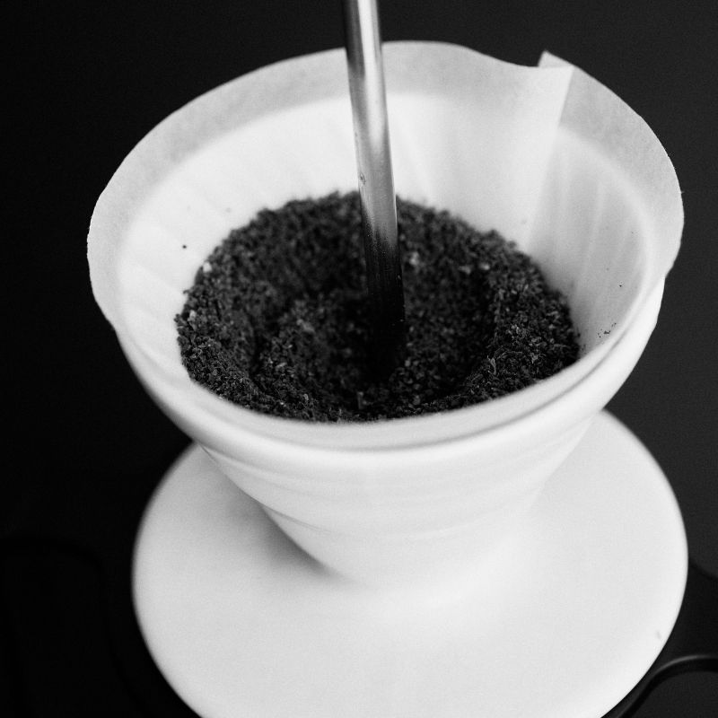 A Sibarist cone filter placed in a dripper, with coffee grounds.